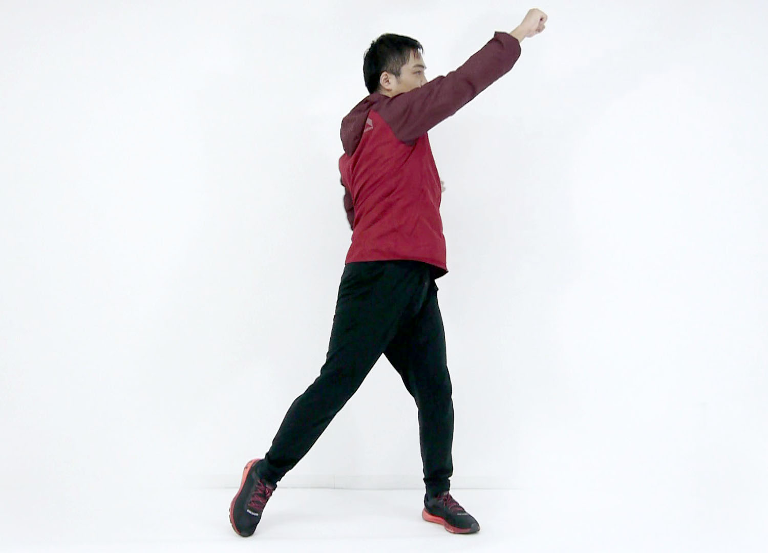 左方向に体をひねりながら右手を左上方に向かって持ち上げます。その際、右足はつま先立ちになる程度に左足に体重を乗せて行きます。